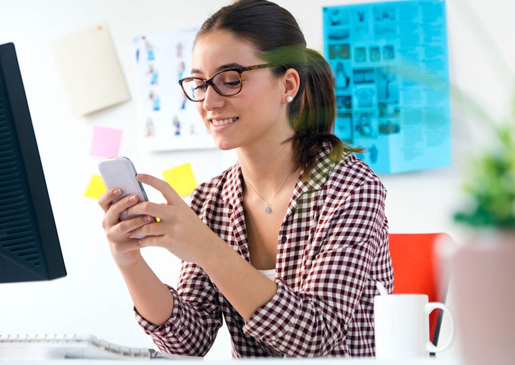 _joven-y-bella-mujer-utilizando-su-telefono-movil-en-la-oficina