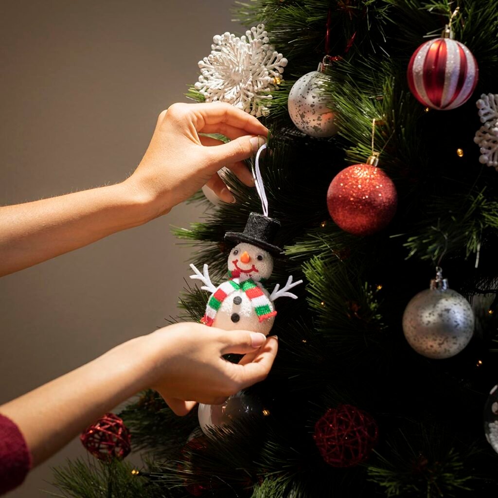 _vista-frontal-manos-poniendo-globos-en-el-arbol-de-navidad