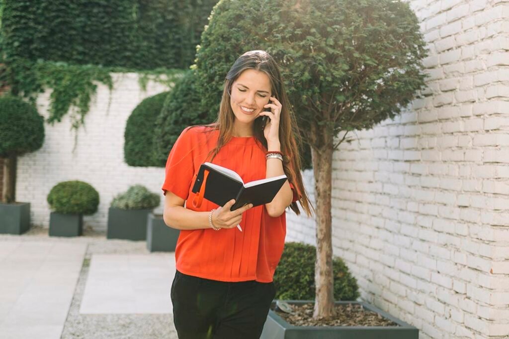 _mujer-mirando-el-horario-en-el-diario-mientras-habla-por-celular