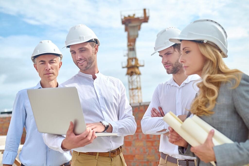 _construction-engineer-showing-something-his-colleagues-his-laptop